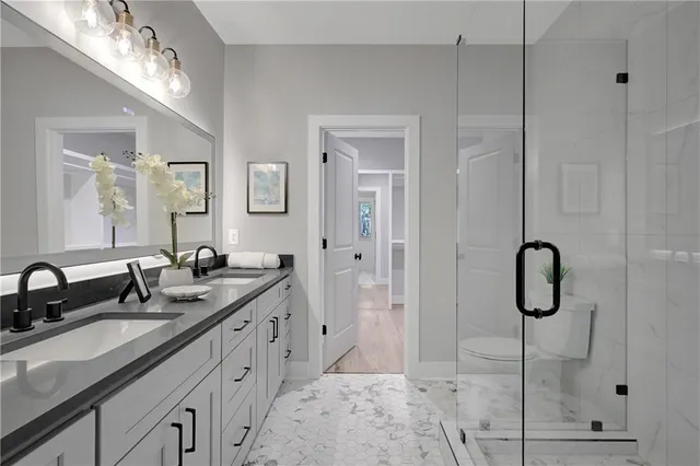 a bathroom with double vanity sinks and a shower