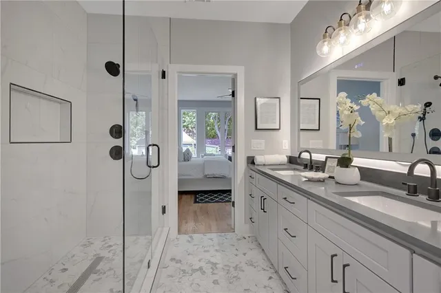 a spacious bathroom with a granite countertop sink mirror and shower