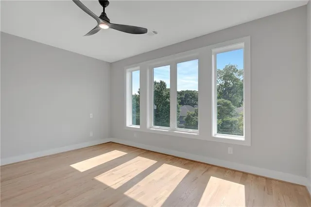 a view of an empty room with a window and wooden floor