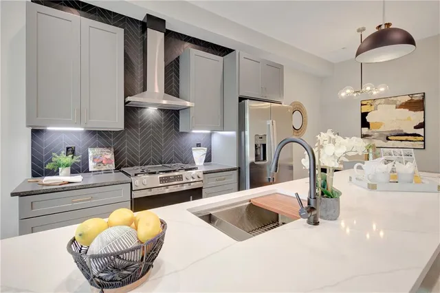 a kitchen with stainless steel appliances a sink a stove and a wooden floor
