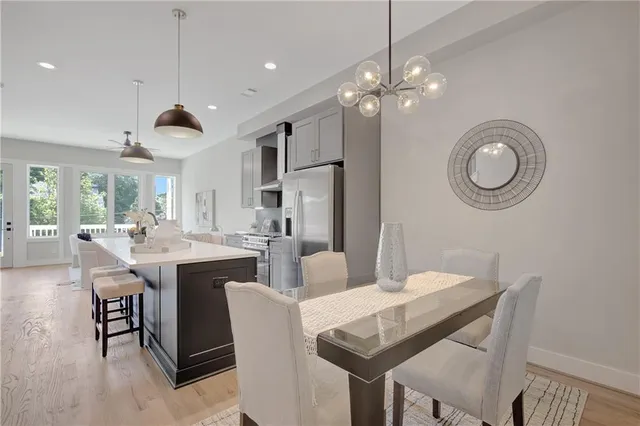 a dining room with wooden floor a chandelier a wooden table and chairs