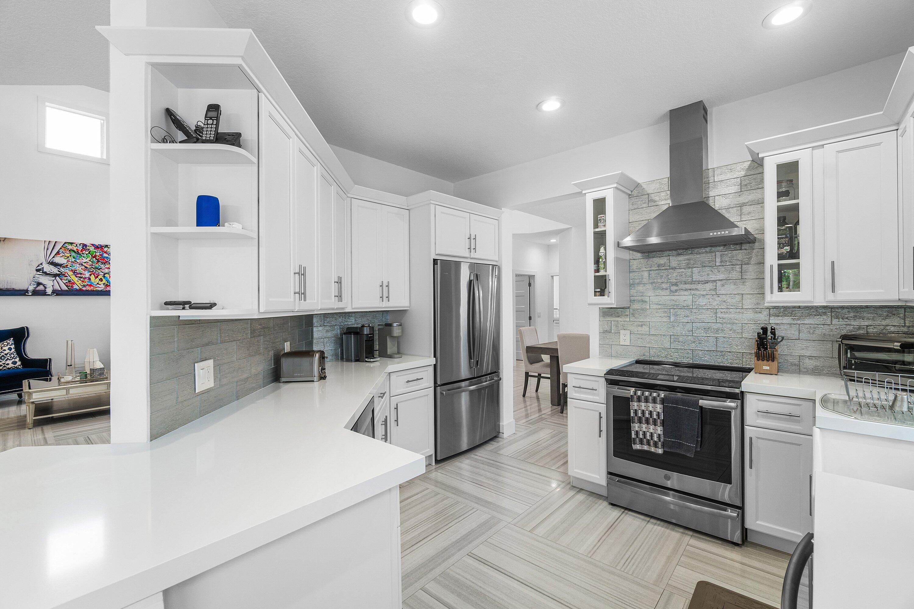 2404 Northwest 67th Street Boca Raton, FL 33496 - Photo 9 of 74 a kitchen with stainless steel appliances a stove sink and refrigerator