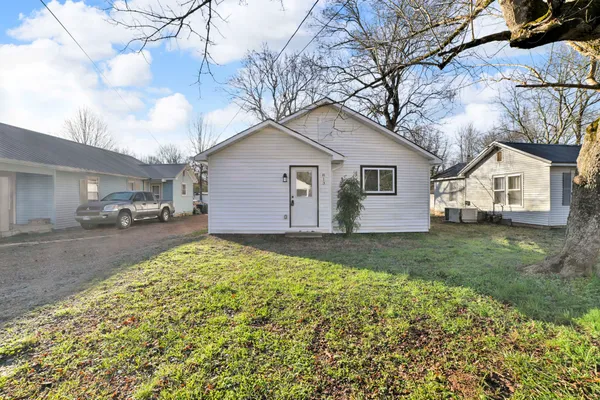 a view of a yard with a house and a large tree