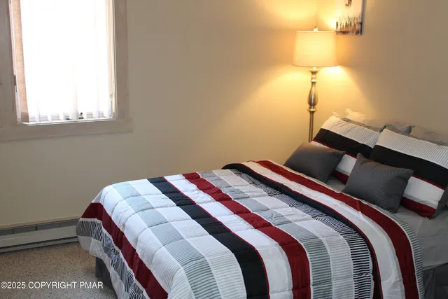 a bedroom with a bed and lamp with the wall