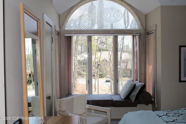 a living room with furniture and floor to ceiling windows