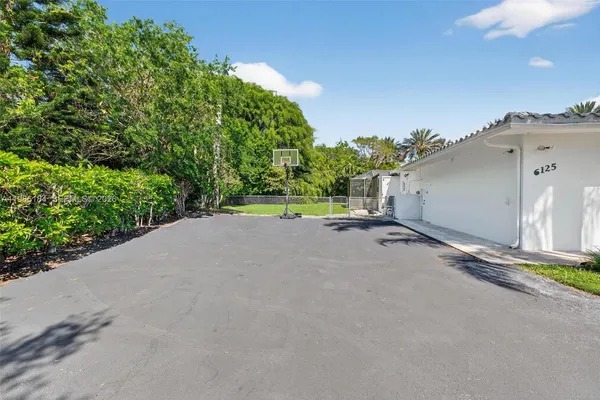 a front view of a house with a garden and trees
