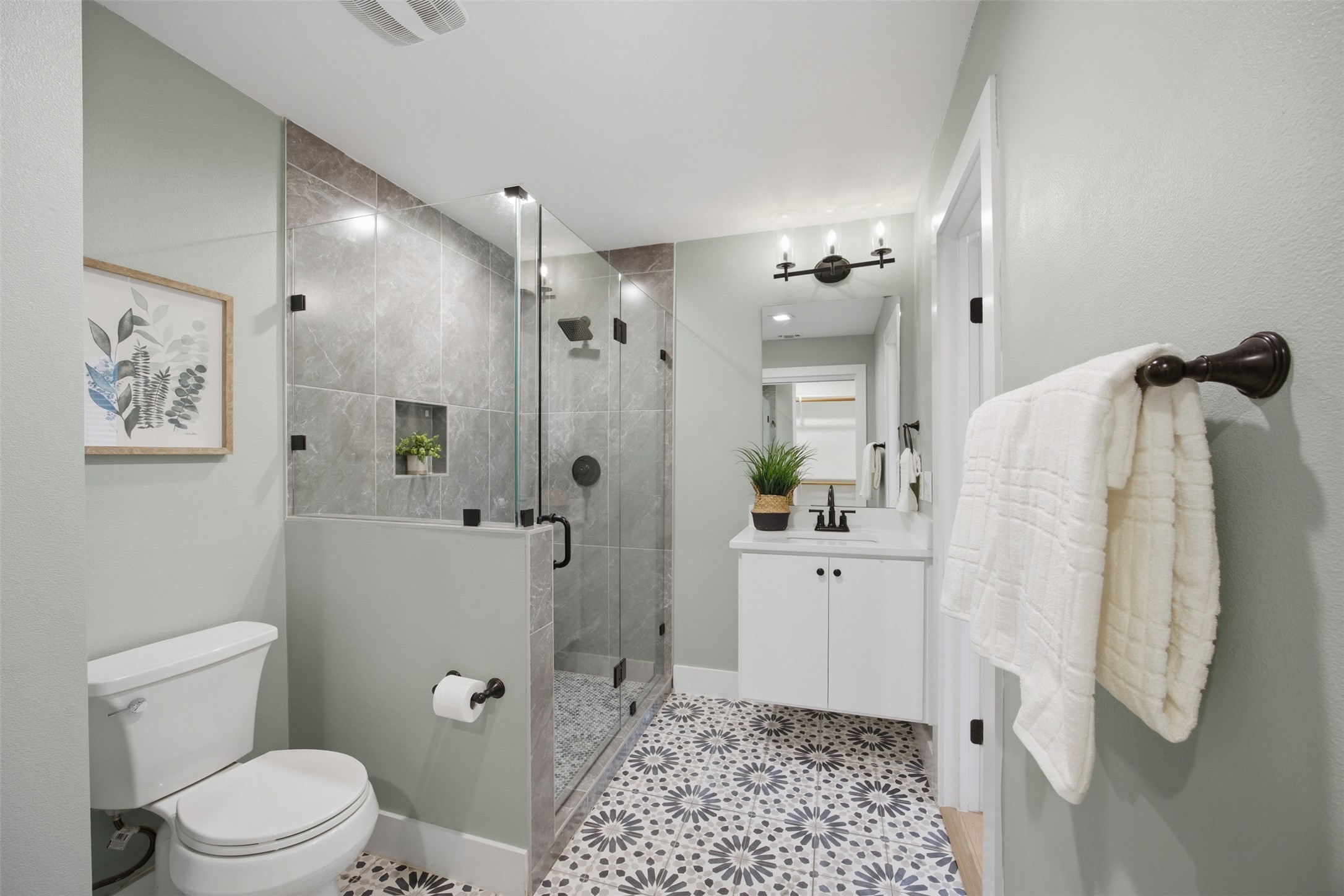 5116 Heflin Lane, Unit 1 Austin, TX 78721 - Photo 22 of 35 A striking patterned tile floor provides a lively foundation for this sleek, modern bathroom with a glass-enclosed shower.