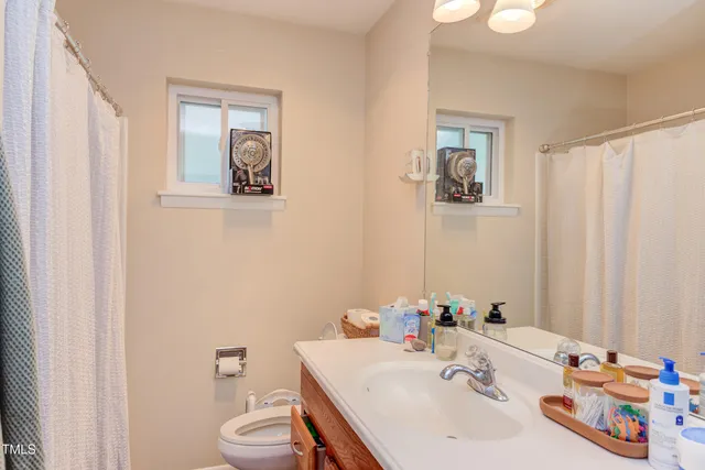 a bathroom with a sink vanity mirror and toilet