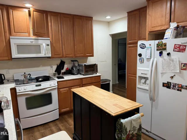 a kitchen with stainless steel appliances kitchen island a refrigerator sink and cabinets