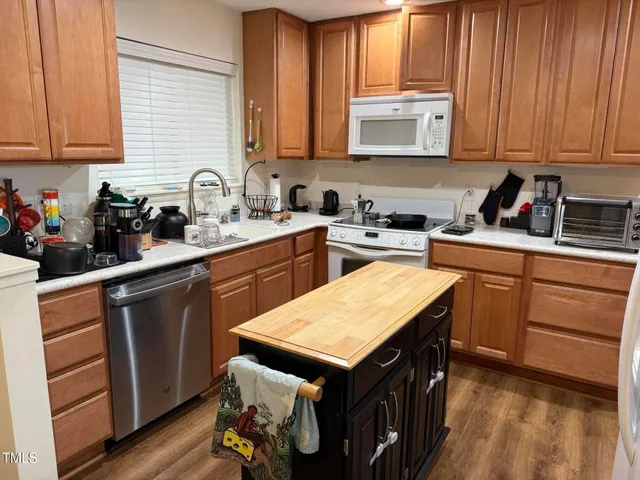 a kitchen with a sink a stove cabinets and wooden floor