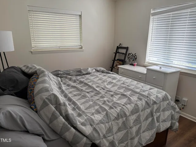 a bed sitting in a bedroom next to a window