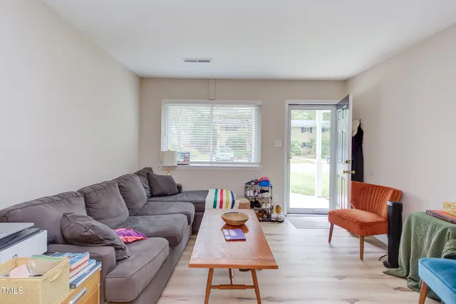a living room with furniture wooden floor and a large window