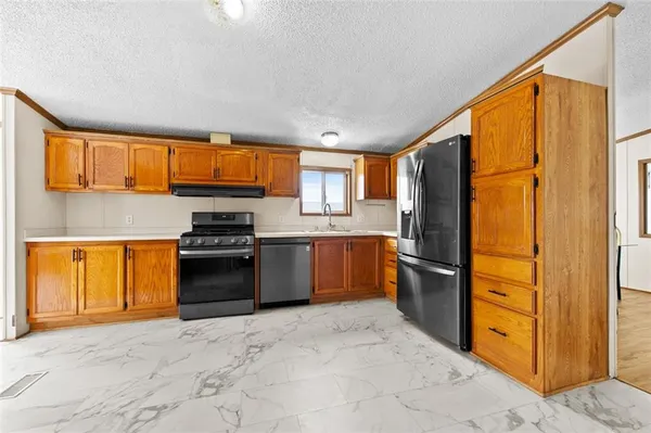 a kitchen with stainless steel appliances granite countertop a refrigerator and a sink