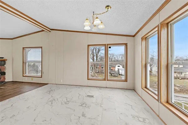 a view of an empty room with window and cabinet