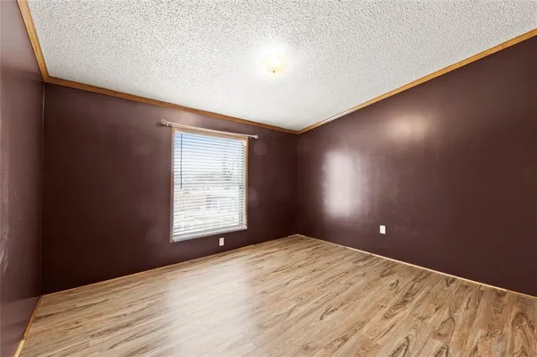 a view of empty room with wooden floor and closet