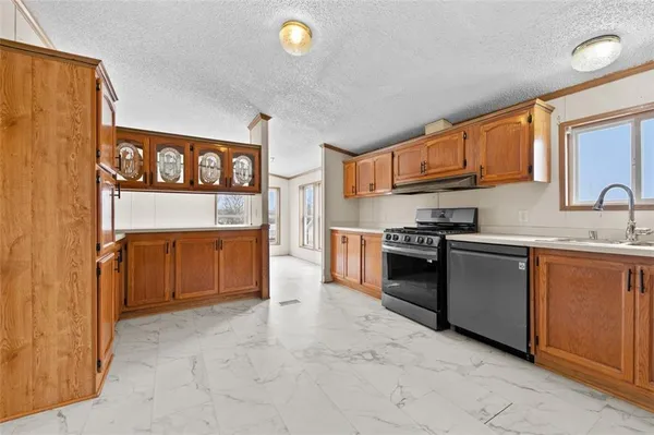 a kitchen with stainless steel appliances a stove a sink and a refrigerator