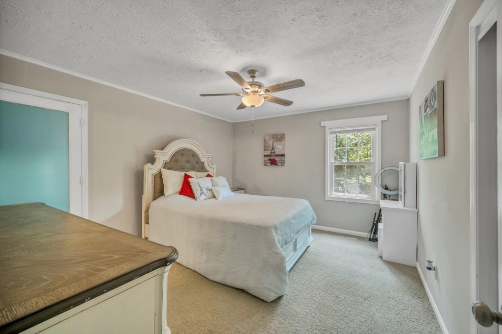 83 Summit Ridge Circle Southeast Cartersville, GA 30120 - Photo 11 of 32 a bedroom with a bed and a chandelier