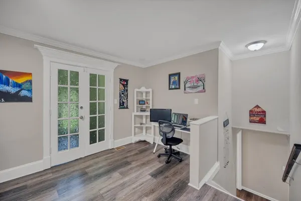 a view of a workspace with furniture and a window