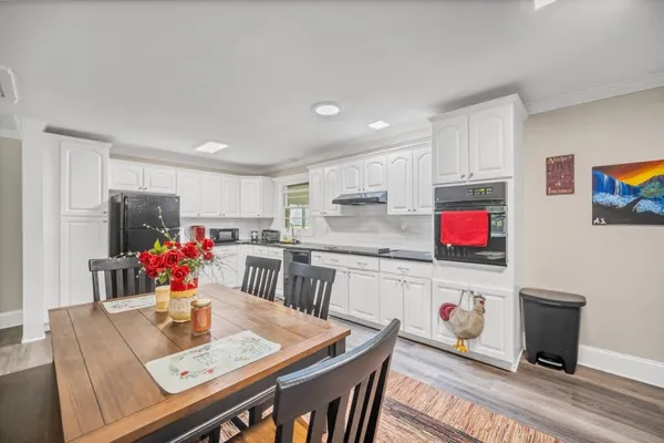 a living room with stainless steel appliances furniture a kitchen view and a refrigerator