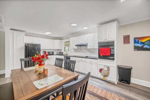 a living room with stainless steel appliances furniture a kitchen view and a refrigerator