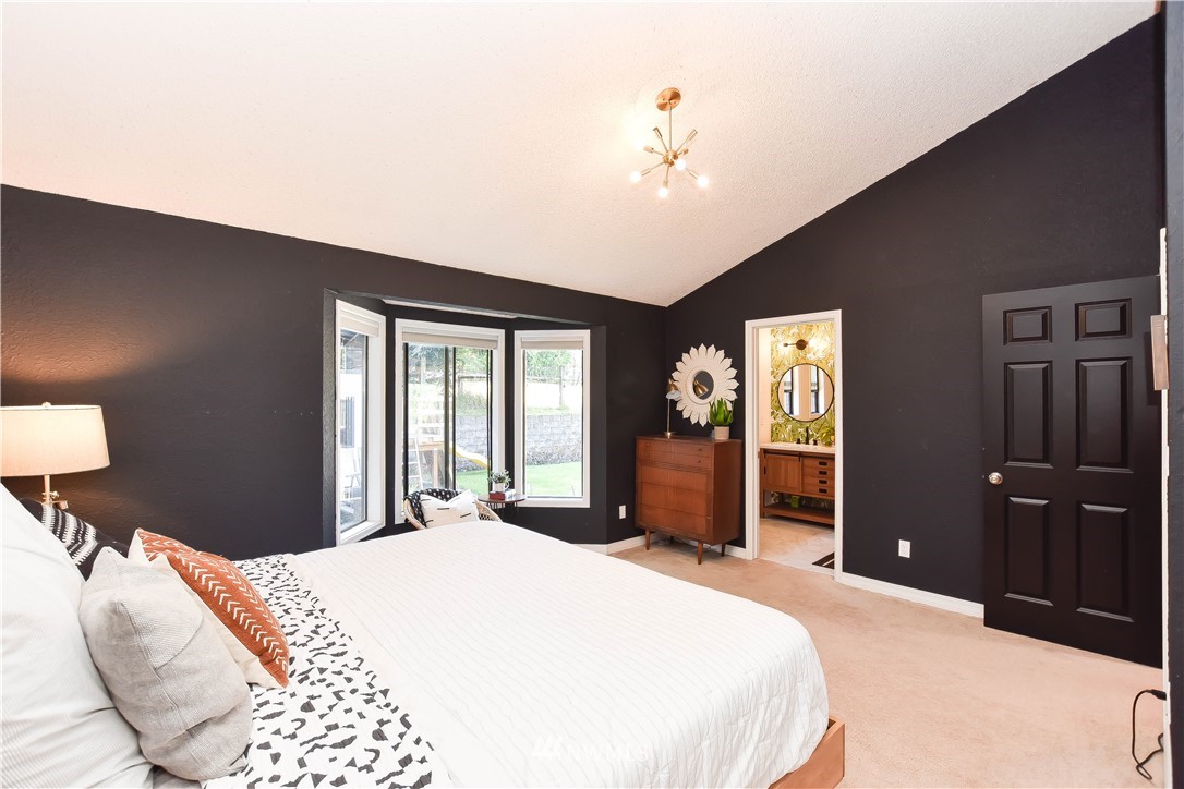 14516 Connelly Road Snohomish, WA 98296 - Photo 24 of 40 a bedroom with a bed and a chandelier