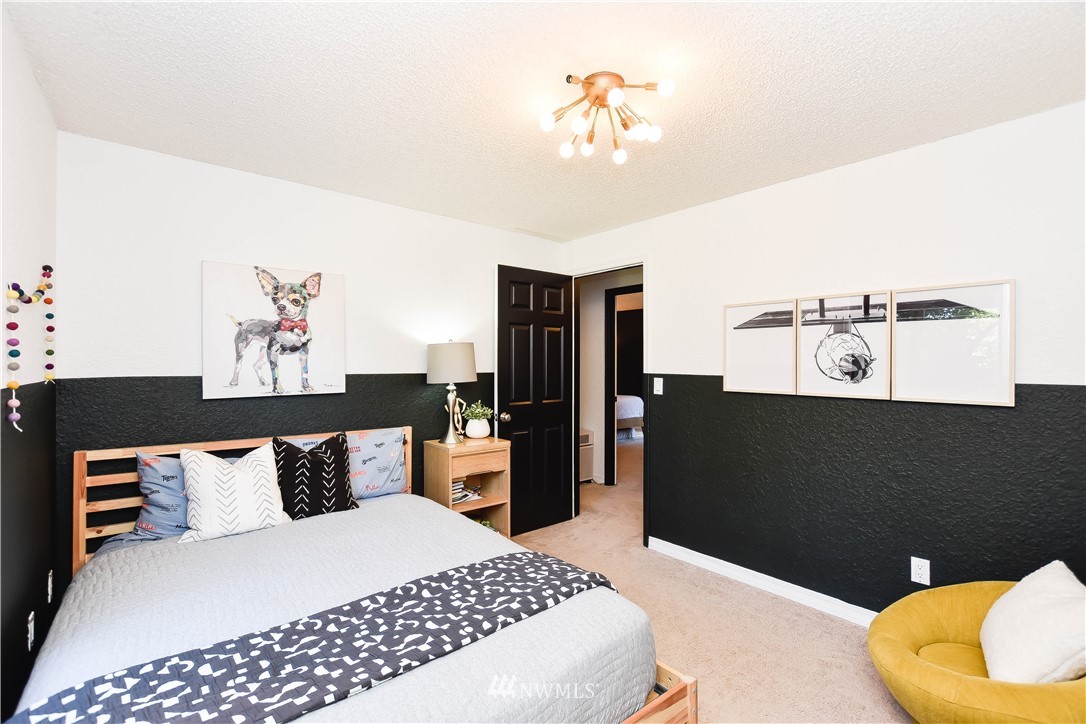 14516 Connelly Road Snohomish, WA 98296 - Photo 33 of 40 a bedroom with a large bed and a chandelier