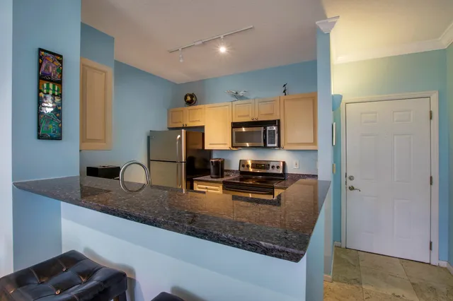 a kitchen with stainless steel appliances granite countertop a sink refrigerator and microwave