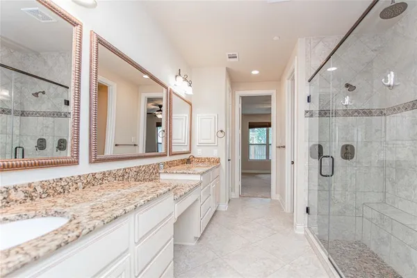 a bathroom with a granite countertop sink mirror and shower
