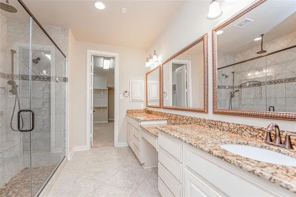 a bathroom with a granite countertop sink and shower