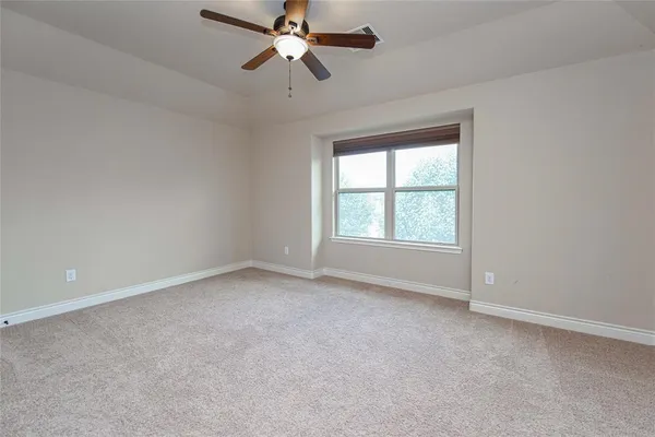 an empty room with a window and a fan