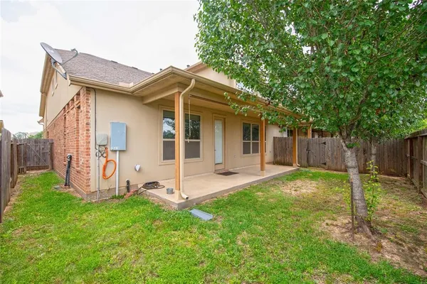 a view of a house with backyard and a tree