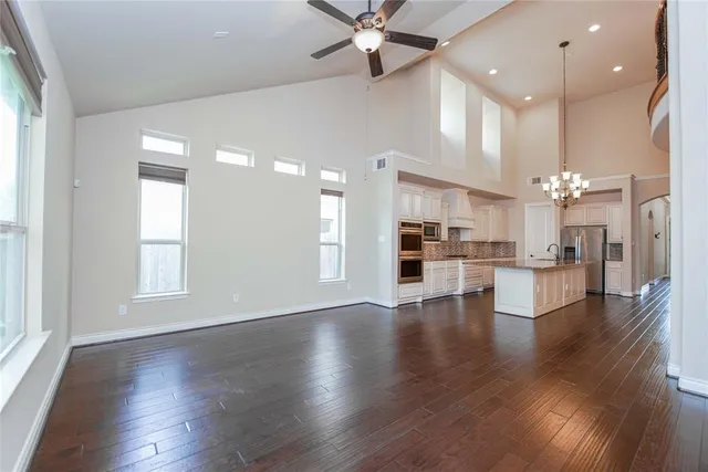 an open kitchen with white cabinets and wooden floor