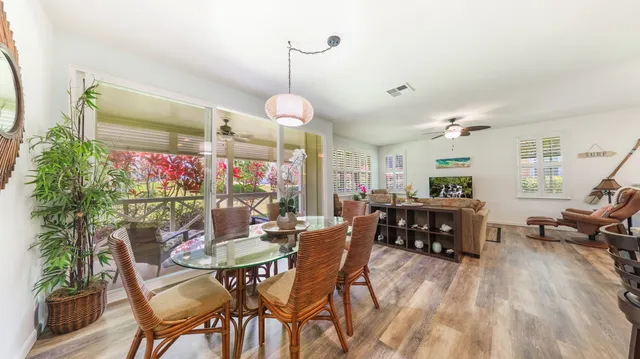 a view of a dining room and livingroom with furniture wooden floor a chandelier