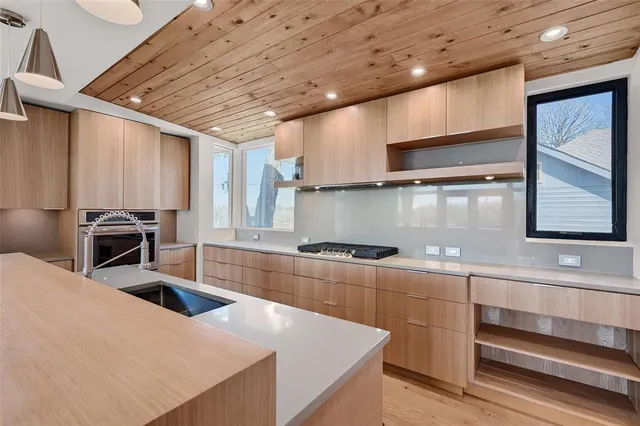 a kitchen with stainless steel appliances granite countertop a sink a stove and a microwave