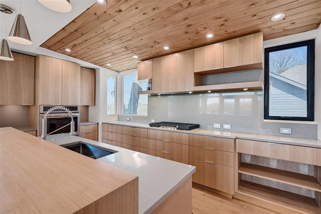 a kitchen with stainless steel appliances granite countertop a sink a stove and a microwave