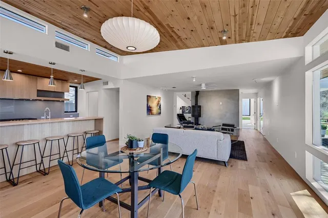 a dining room with wooden floor a glass table and chairs