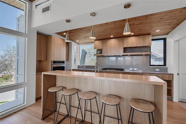 a kitchen with stainless steel appliances granite countertop a sink a stove and a refrigerator