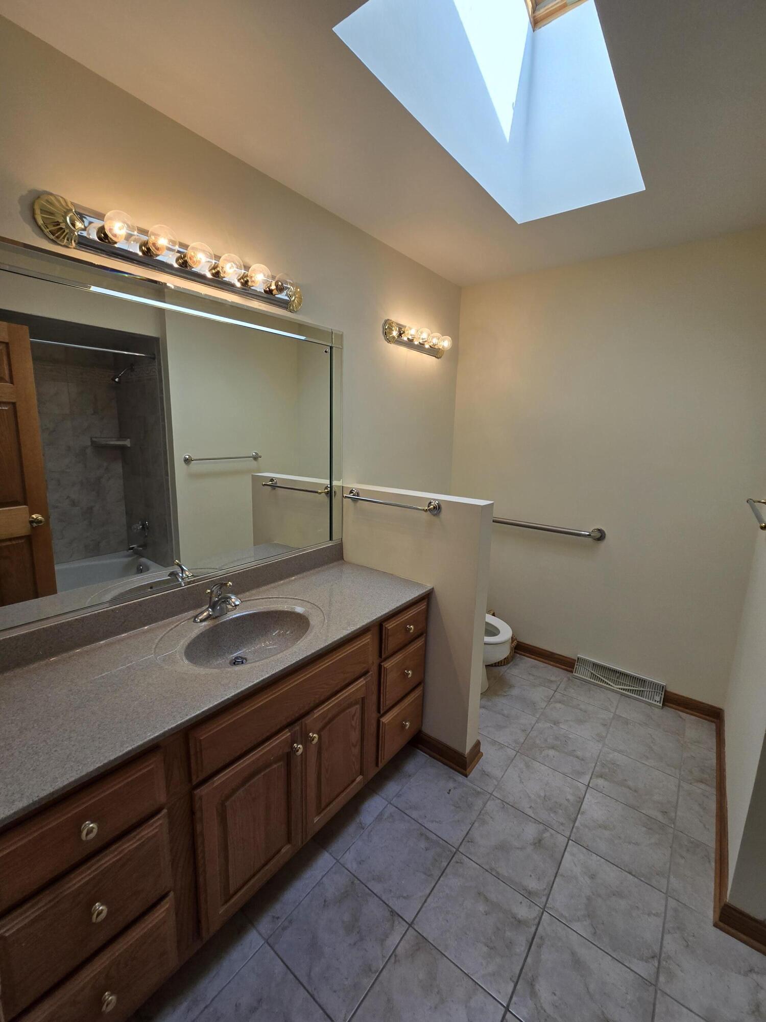 1828 Wren Drive Munster, IN 46321 - Photo 12 of 36 a bathroom with a granite countertop sink a toilet and a mirror