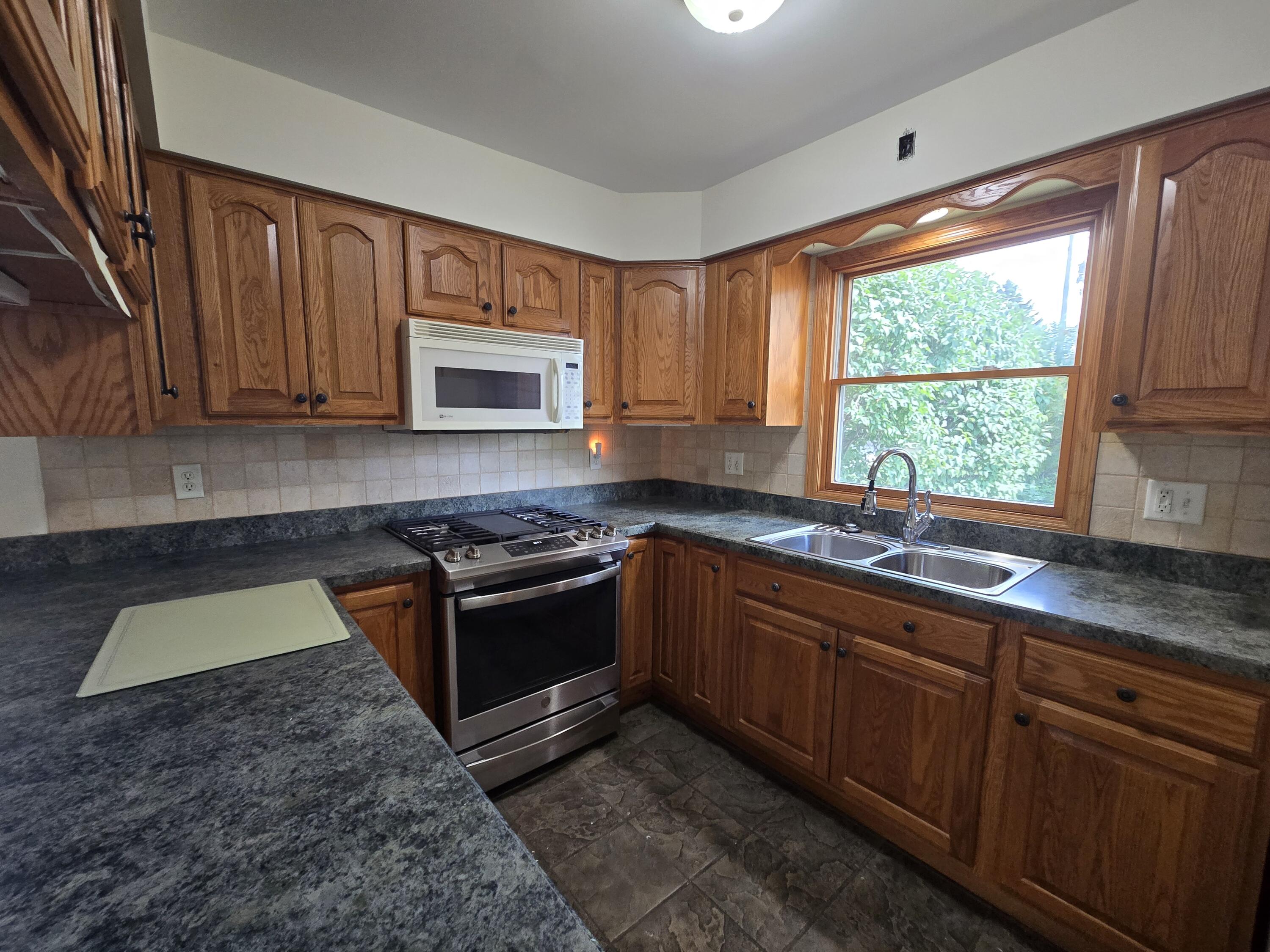 1828 Wren Drive Munster, IN 46321 - Photo 7 of 36 a kitchen with stainless steel appliances granite countertop a stove a sink and a microwave
