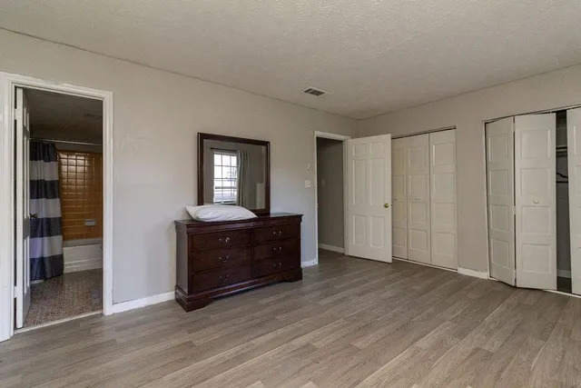 a living room with a mirror and a wooden floor