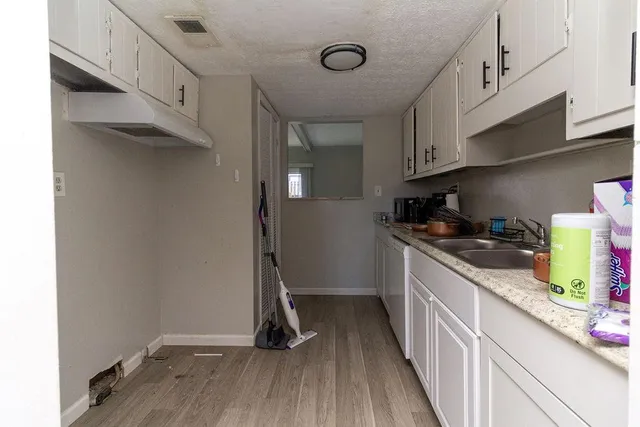 a kitchen with granite countertop a sink and cabinets