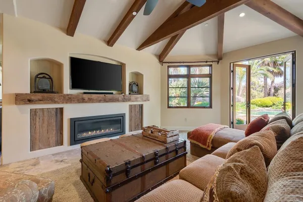 a living room with furniture a fireplace and a flat screen tv