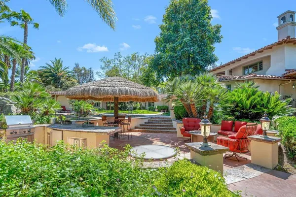 a backyard of a house with a garden and outdoor seating