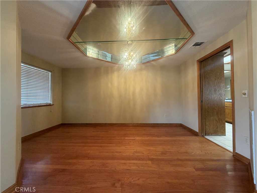 19609 Seneca Road Apple Valley, CA 92307 - Photo 12 of 37 an empty room with wooden floor and windows