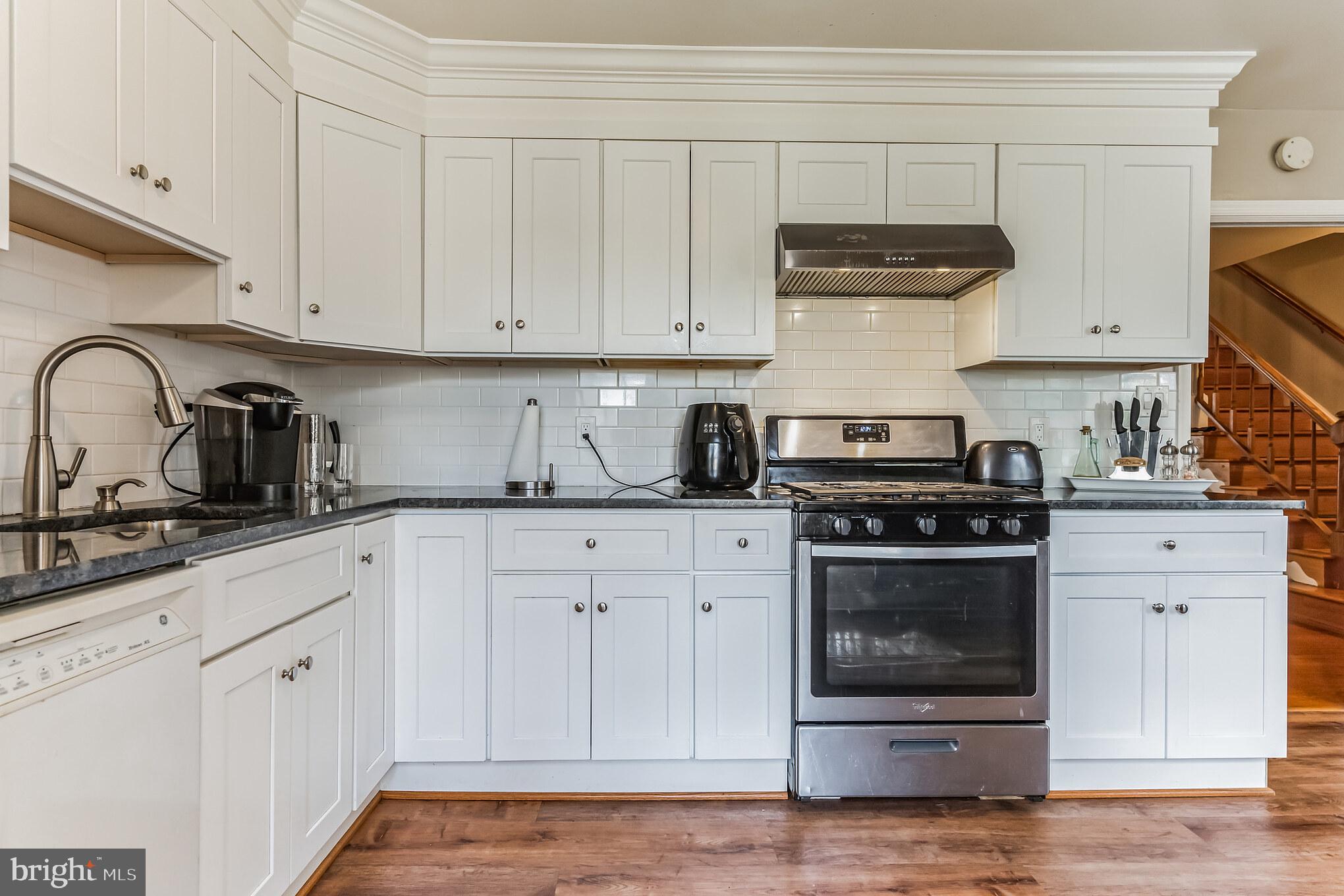 4926 Carriagepark Road Fairfax, VA 22032 - Photo 11 of 34 a kitchen with white cabinets and stainless steel appliances