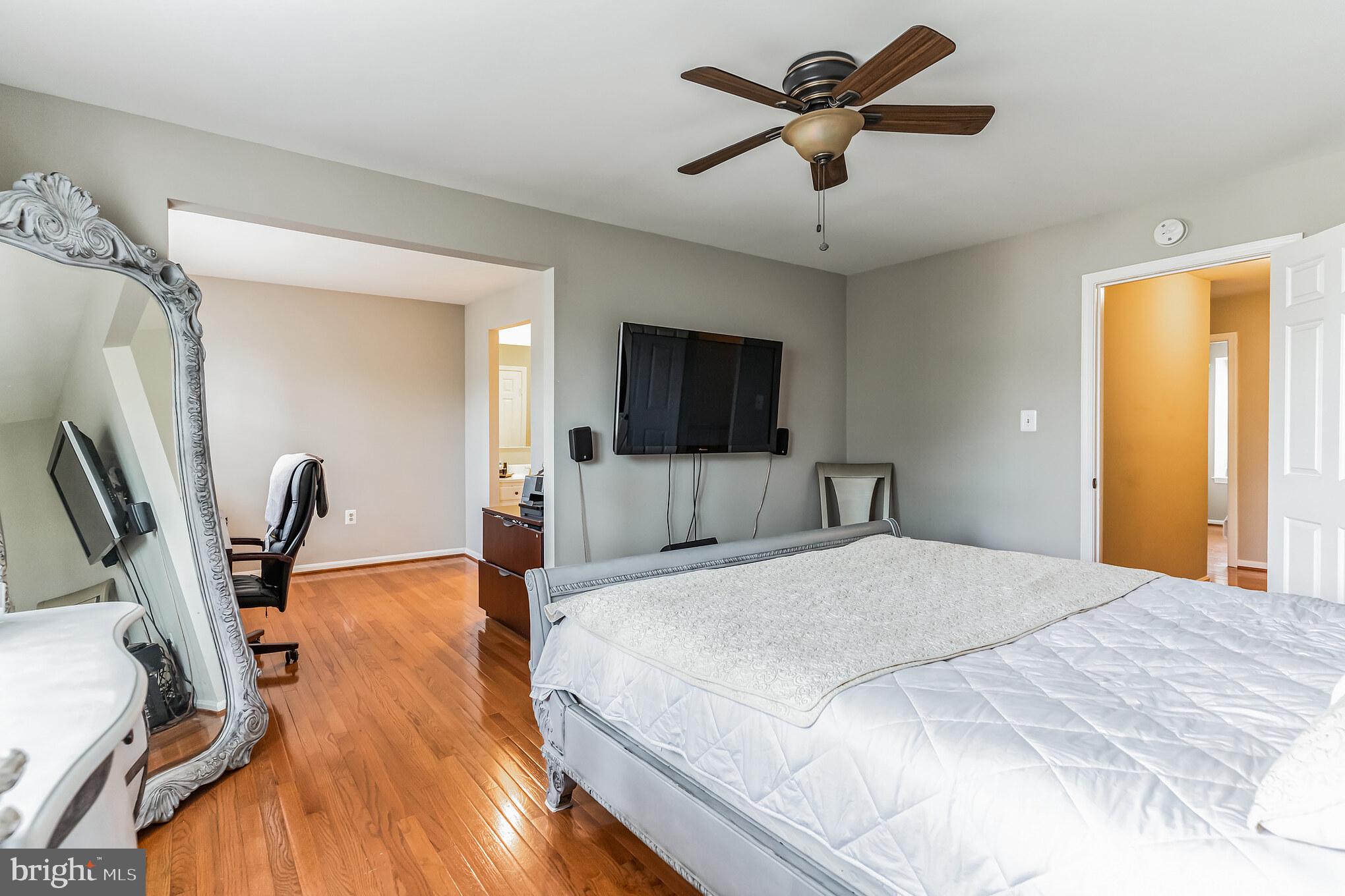4926 Carriagepark Road Fairfax, VA 22032 - Photo 20 of 34 a bedroom with a bed a flat screen tv and a chandelier