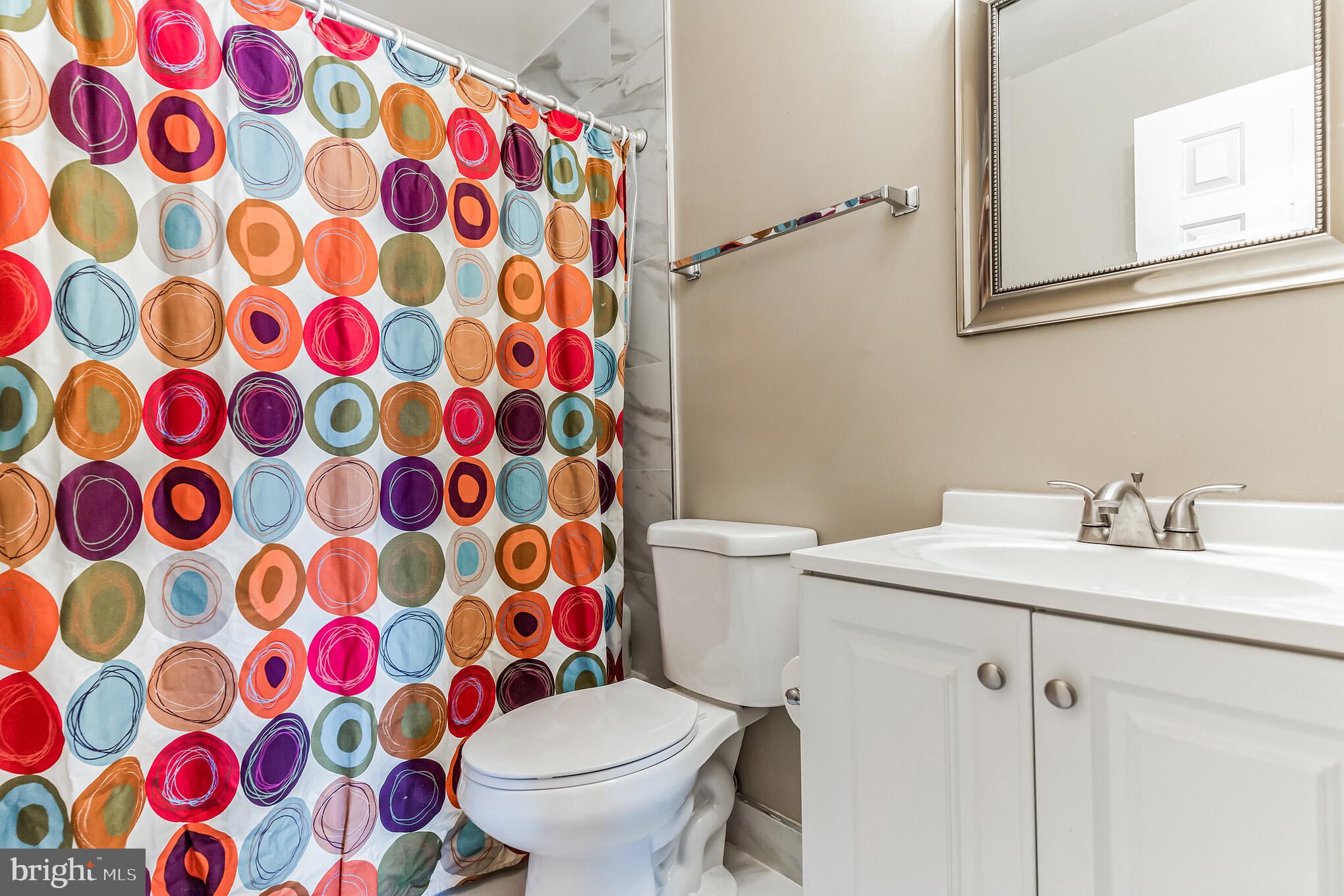 4926 Carriagepark Road Fairfax, VA 22032 - Photo 28 of 34 a white toilet sitting next to a shower curtain