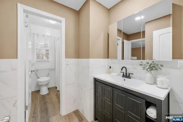 a bathroom with a sink a toilet and a mirror