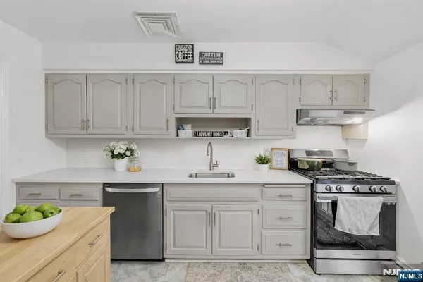 a kitchen with stainless steel appliances granite countertop a sink stove and cabinets
