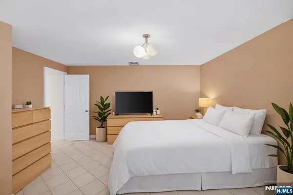 a bedroom with a bed and a television